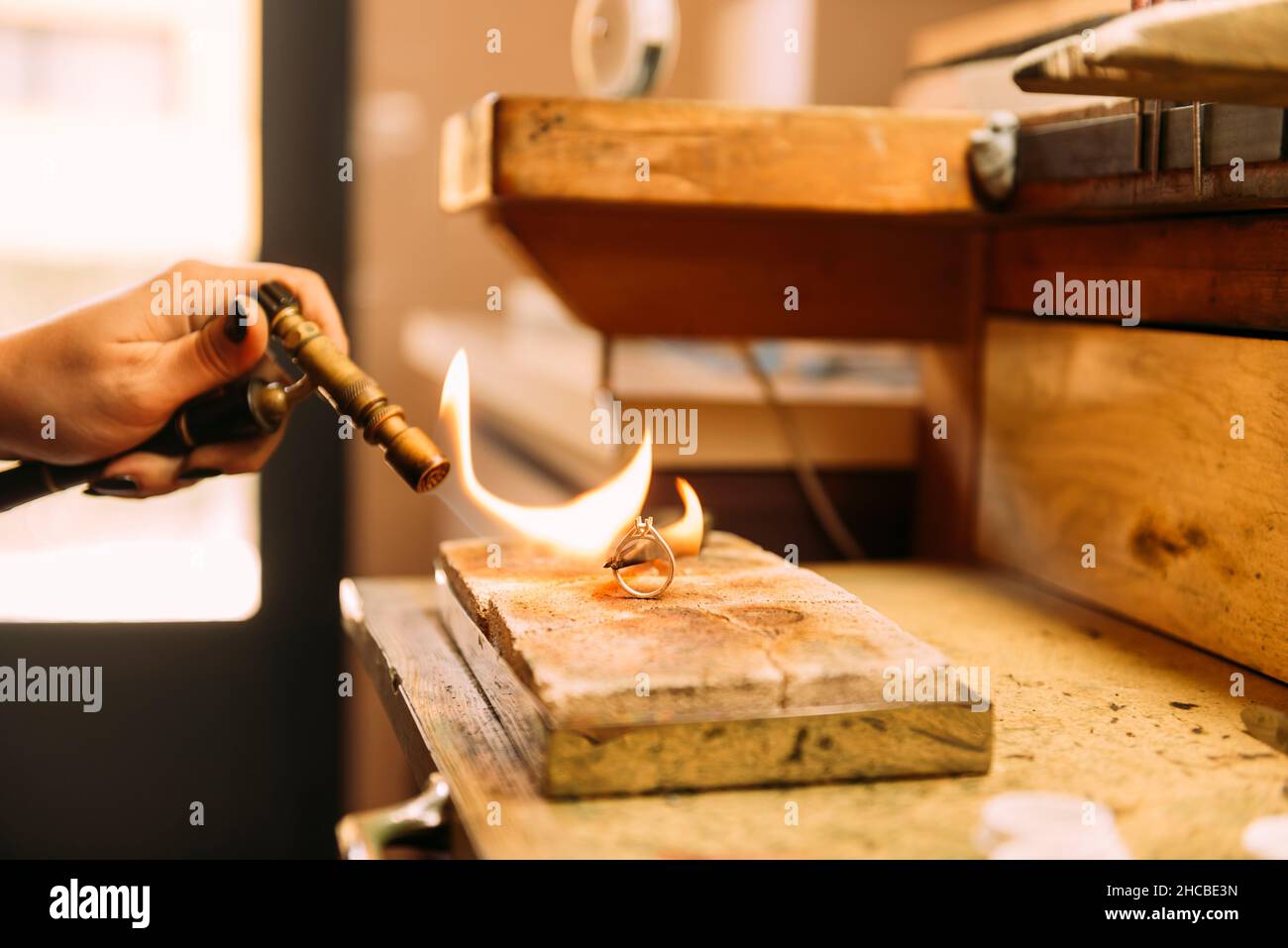 Female jeweler using hand saw to cut silver ring Stock Photo Alamy