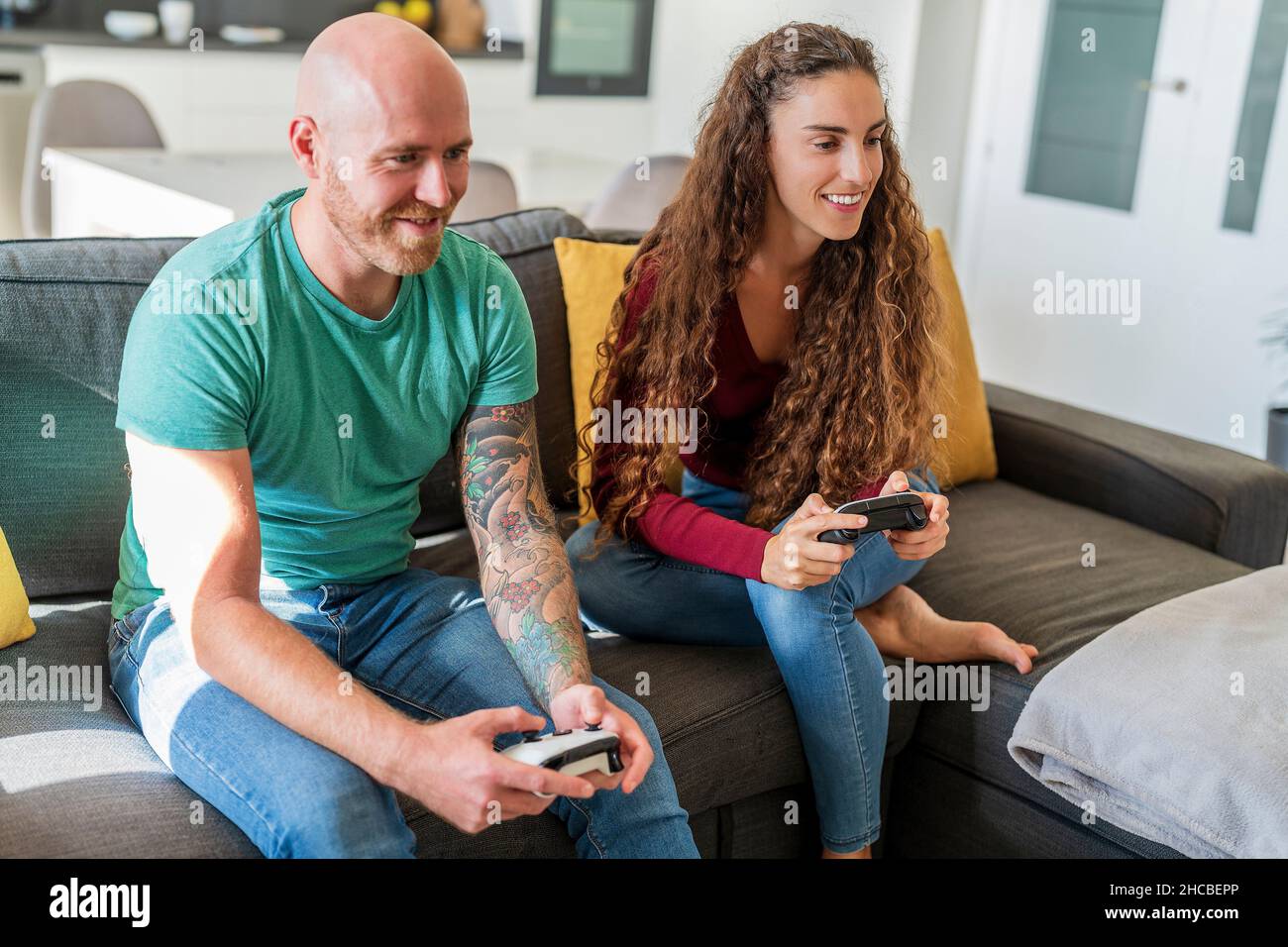 Smiling couple playing video games at home Stock Photo