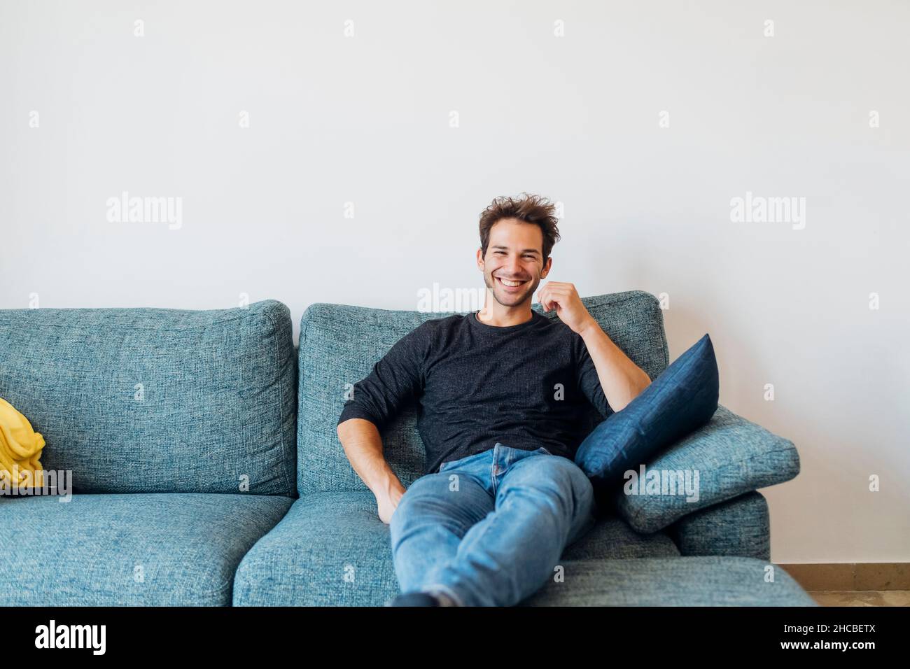 Man sofa smile young hi-res stock photography and images - Alamy