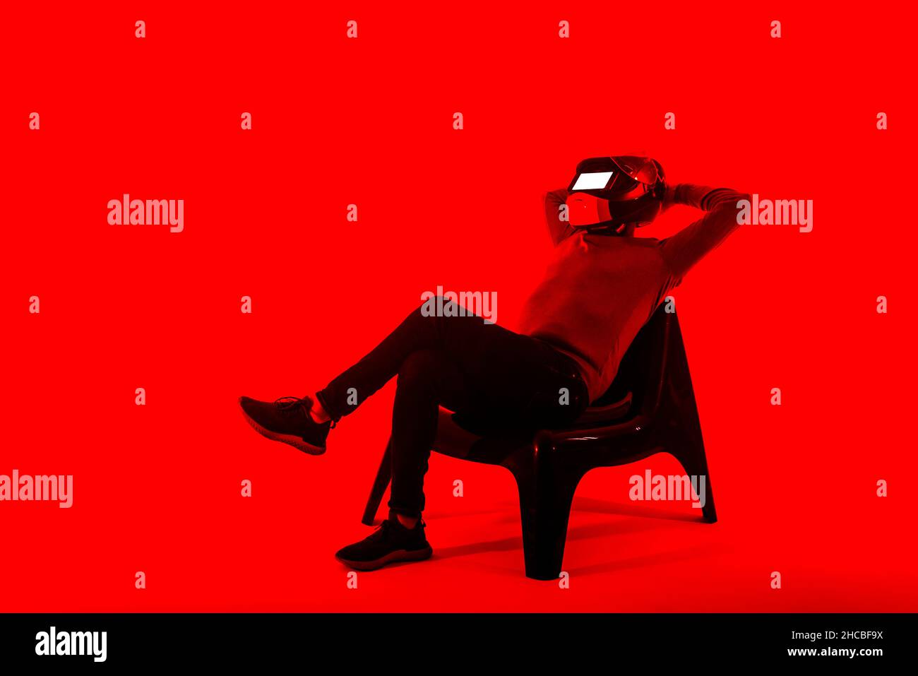Man wearing helmet using digital tablet on red background Stock Photo