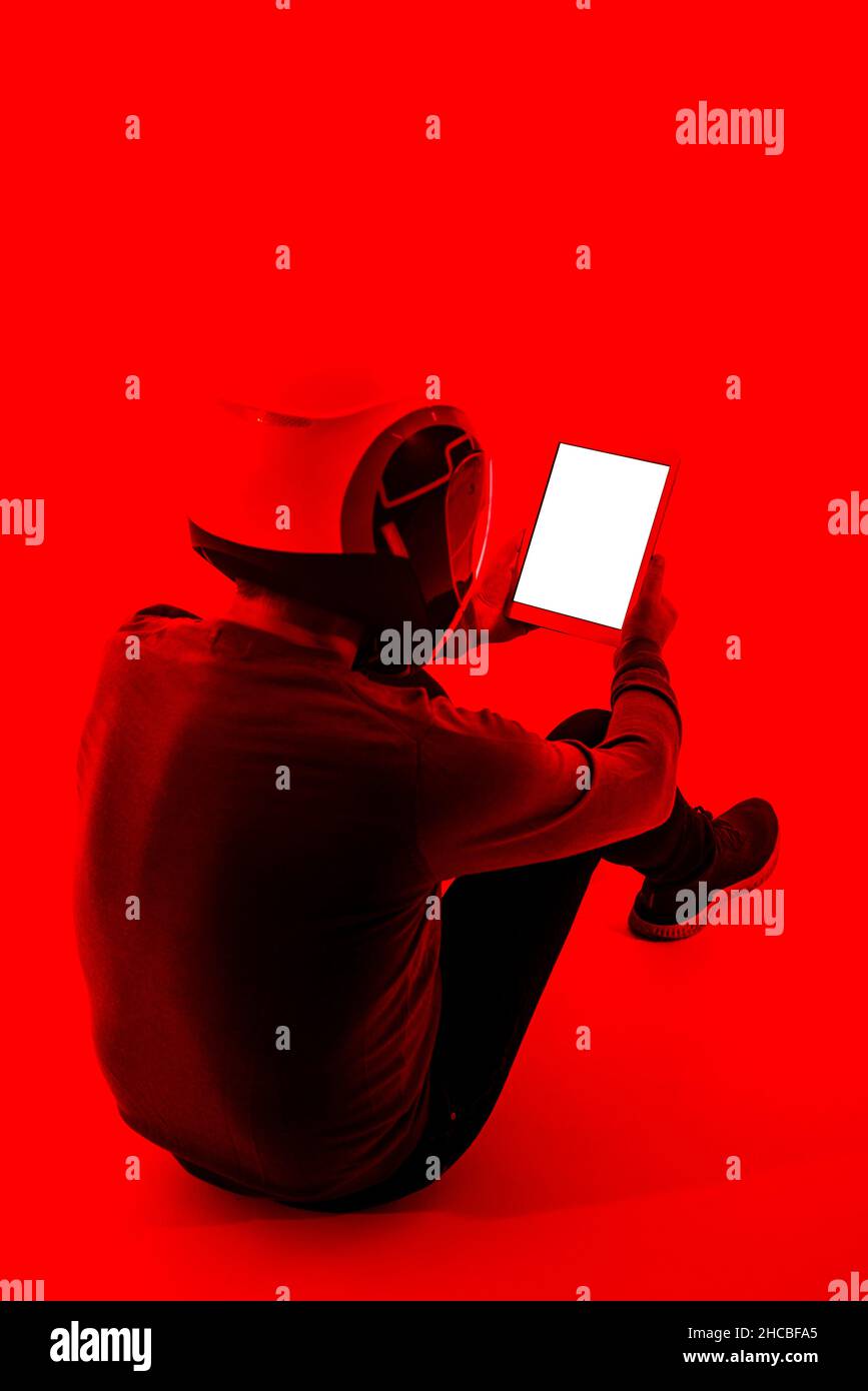 Man holding digital tablet above head against red background Stock Photo