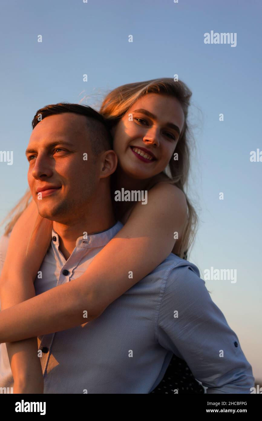 Man piggybacking happy woman Stock Photo