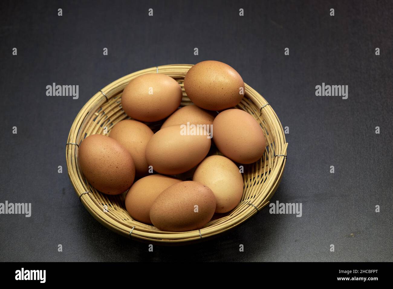 Fresh brown chicken eggs in wicker basket Stock Photo