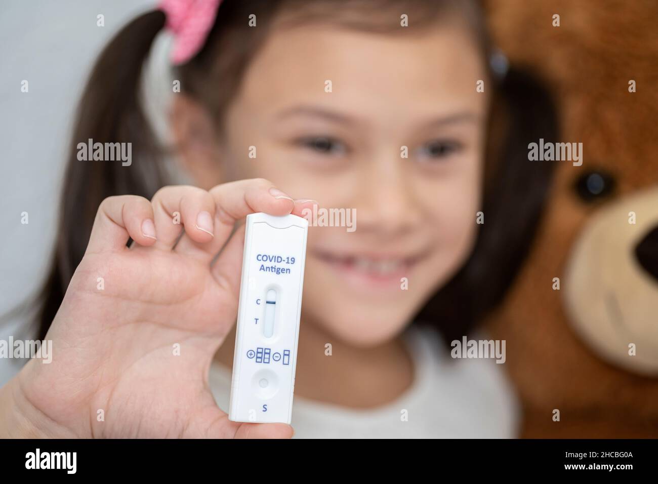 Smiling girl showing negative COVID-19 test Stock Photo
