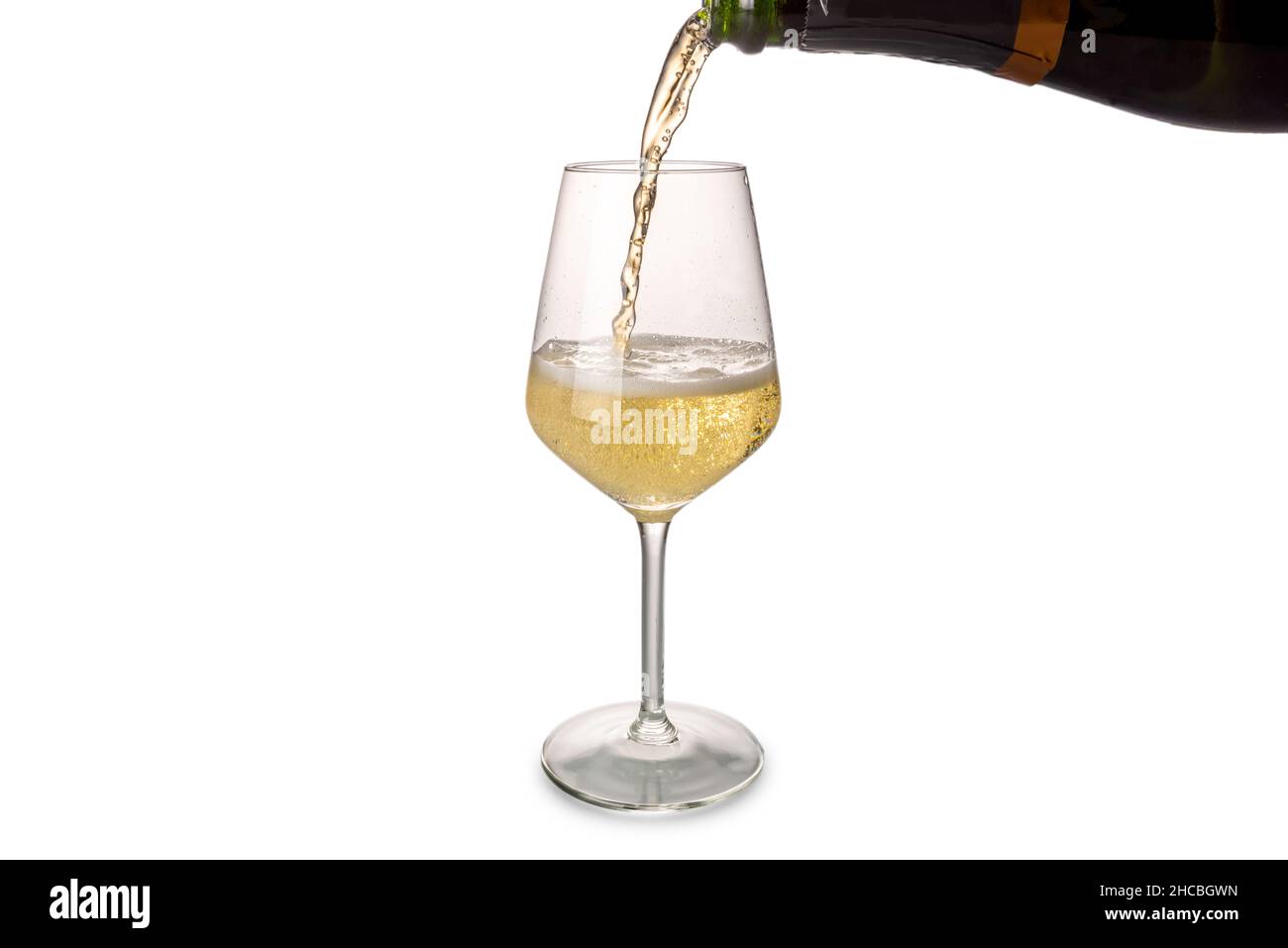 Champagne or sparkling wine pouring into glass from bottle with splashing,  isolated on white, copy space Stock Photo