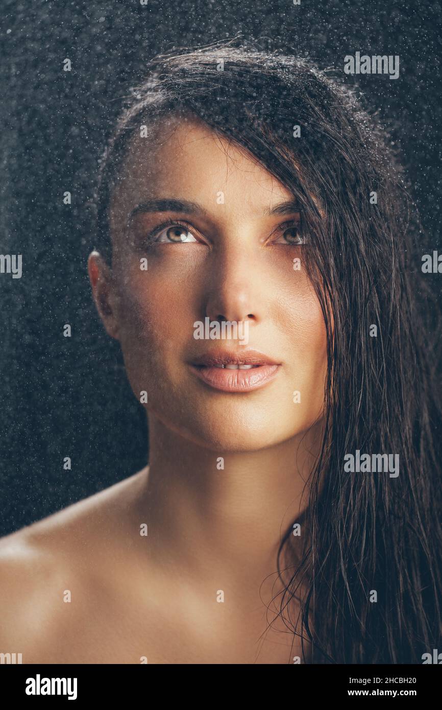 Beautiful woman looking at water drops Stock Photo