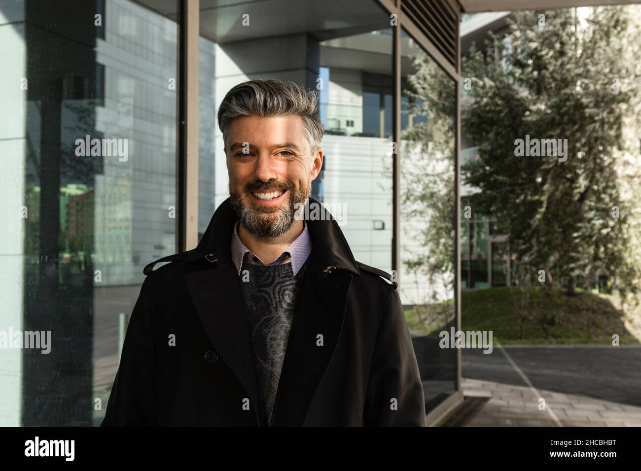 Businessman raising eyebrow in front of building Stock Photo