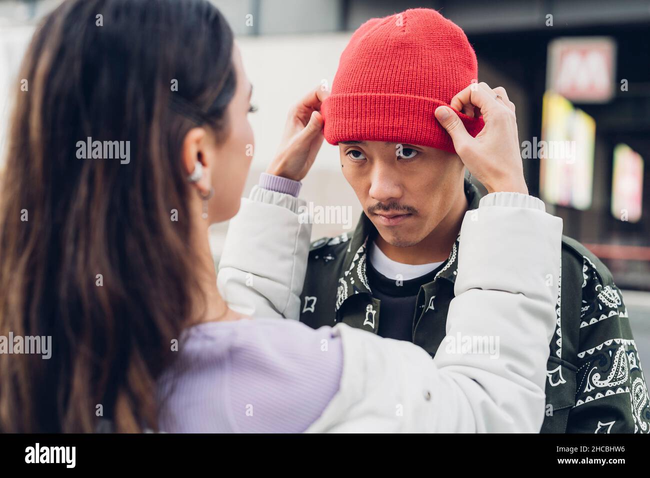 Woman adjusting boyfriend's knit hat Stock Photo