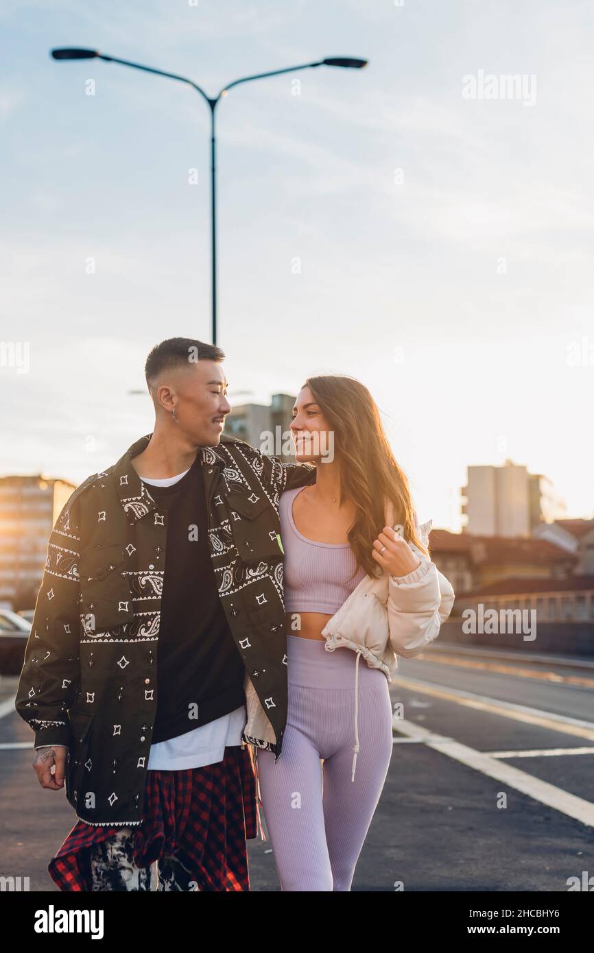 Romantic couple looking at each other and walking on road Stock Photo