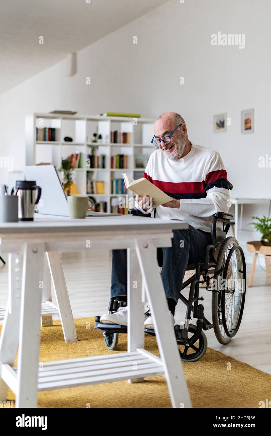Senior disabled man reading diary at home office Stock Photo