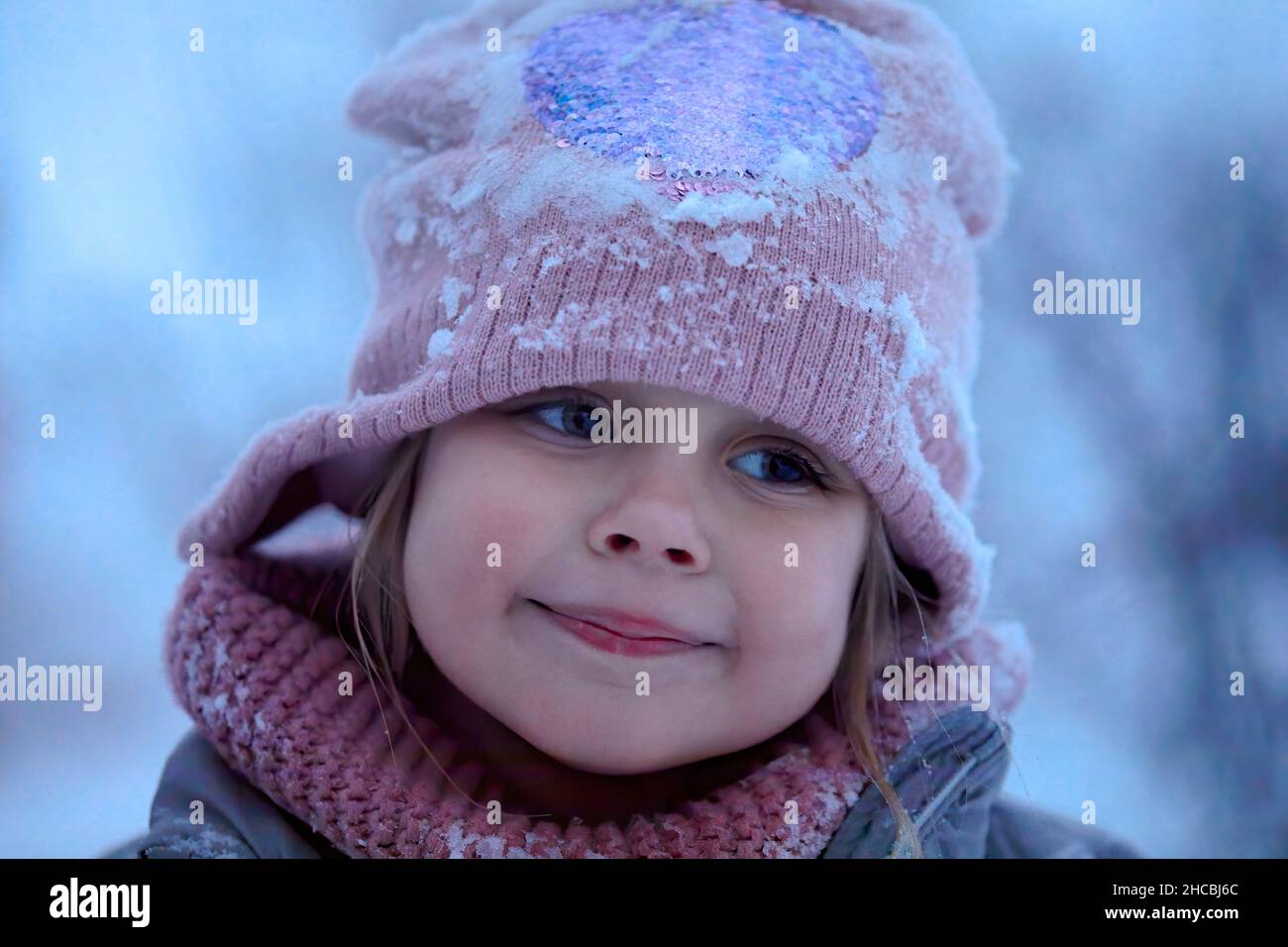 Cute smiling girl wearing knit hat with snow Stock Photo