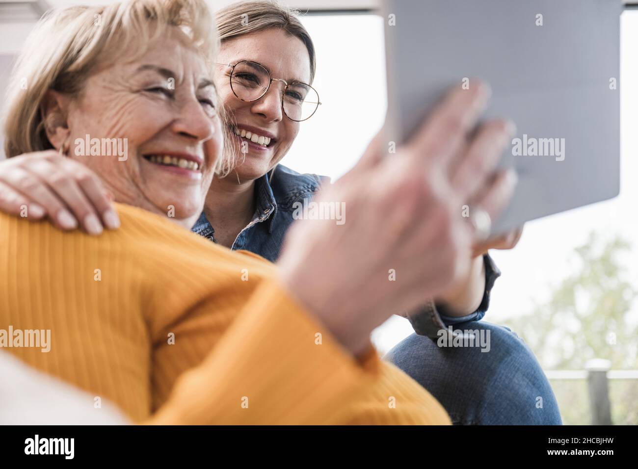 Smiling women using tablet PC at home Stock Photo