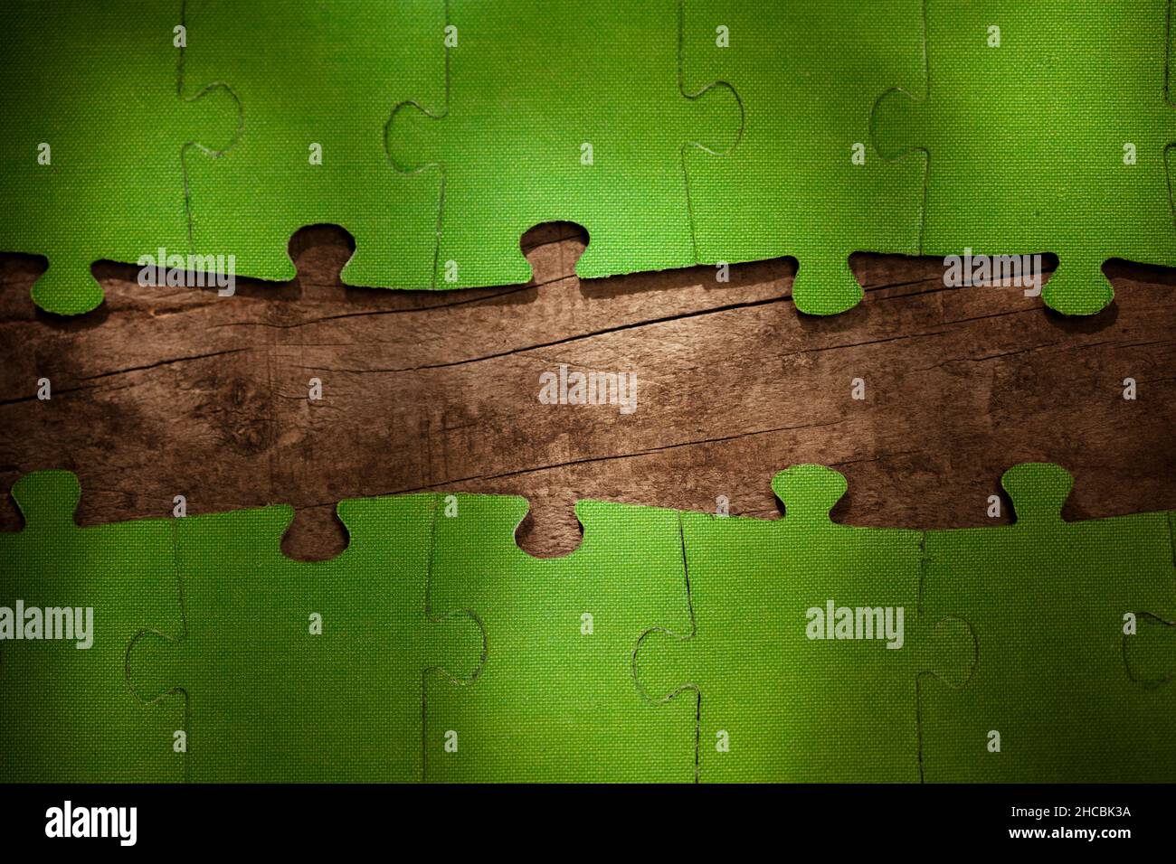 Incomplete green jigsaw puzzle pieces on table Stock Photo