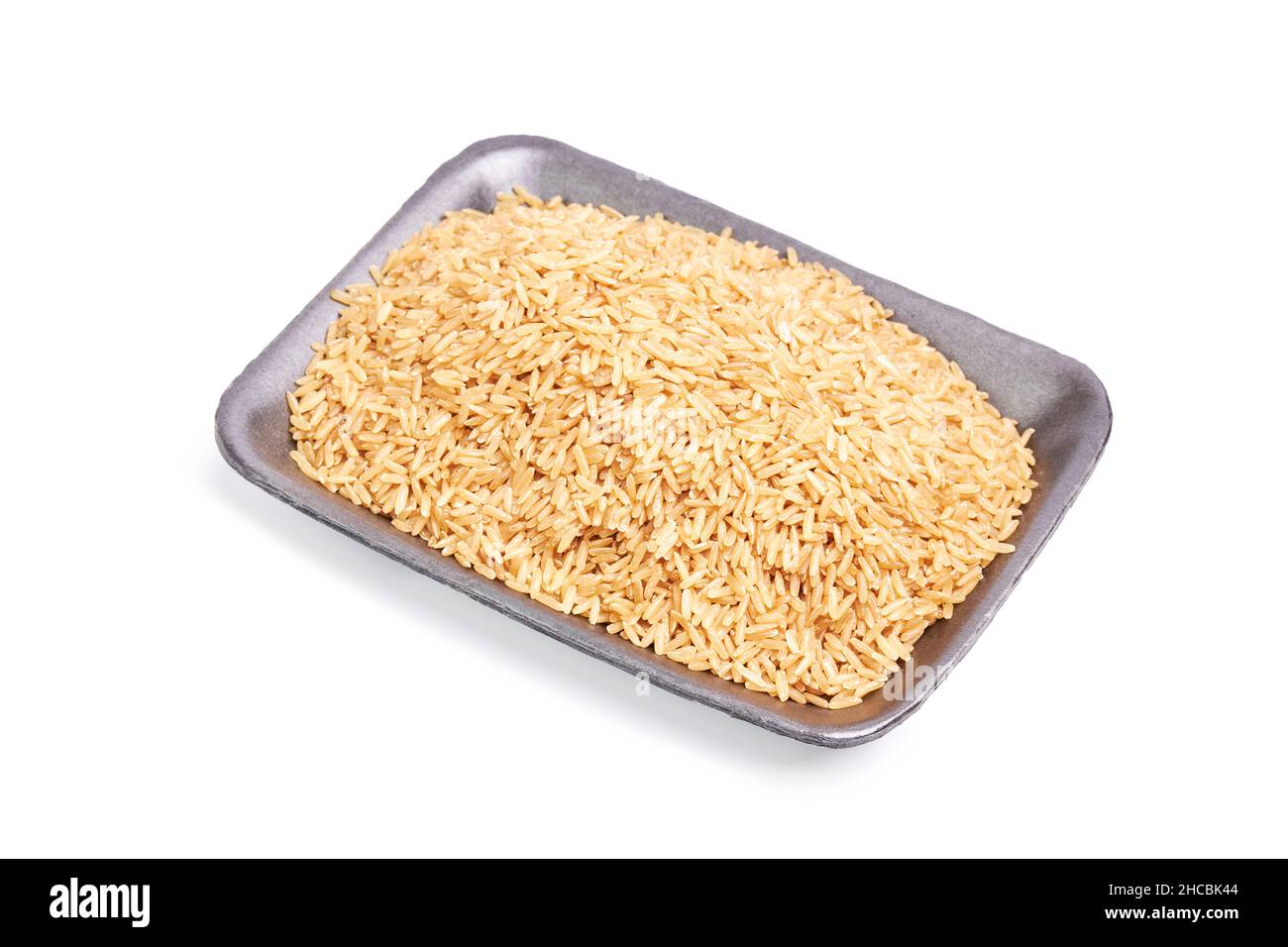 Black tray with raw rice on a white background. Asian food. Healthy food concept Stock Photo