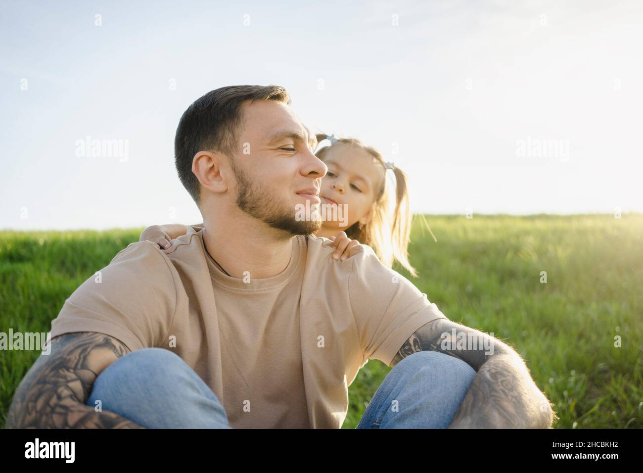 Father and daughter spending leisure time on meadow Stock Photo
