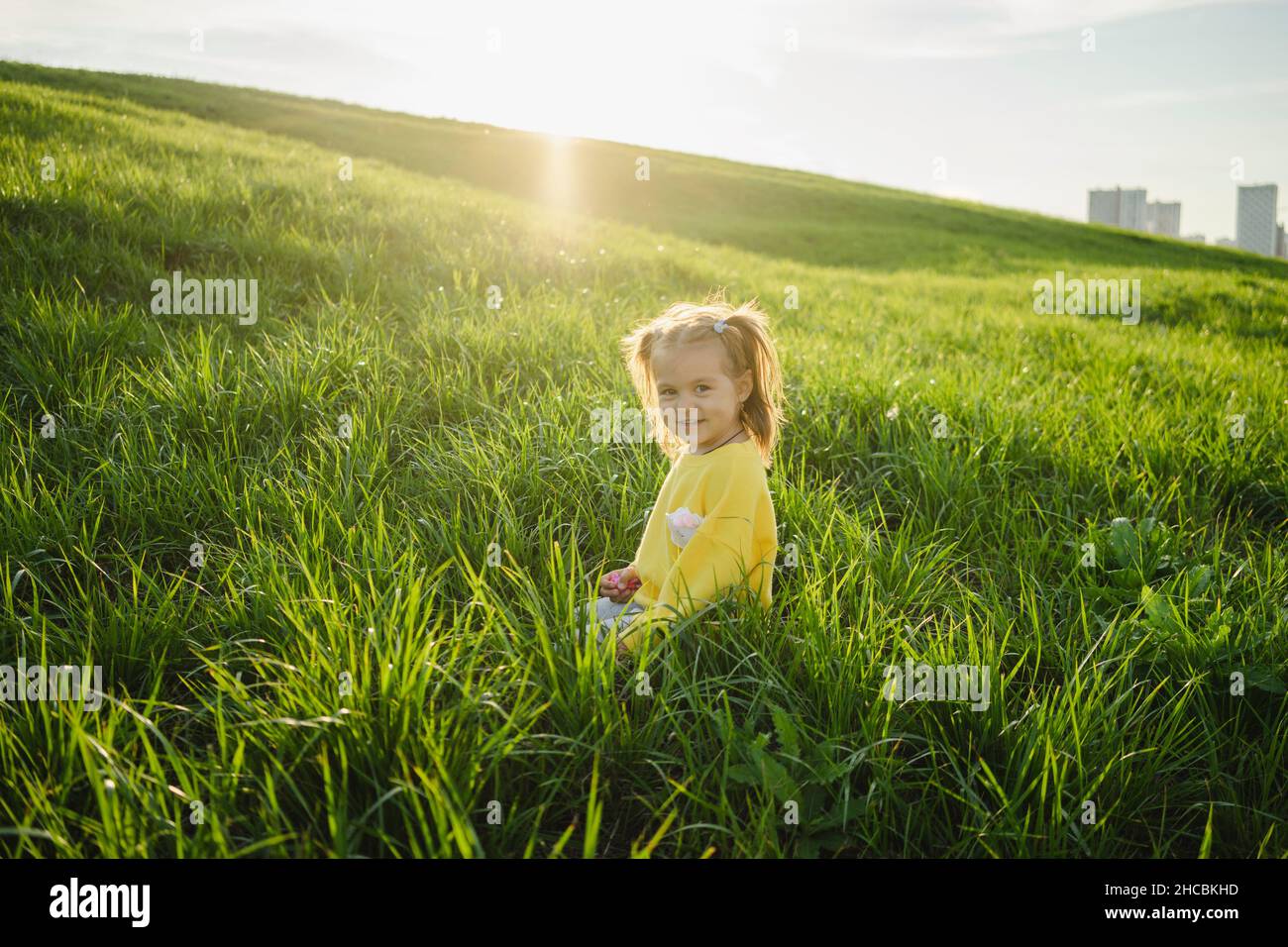 Girl sitting on green grass hi-res stock photography and images - Alamy