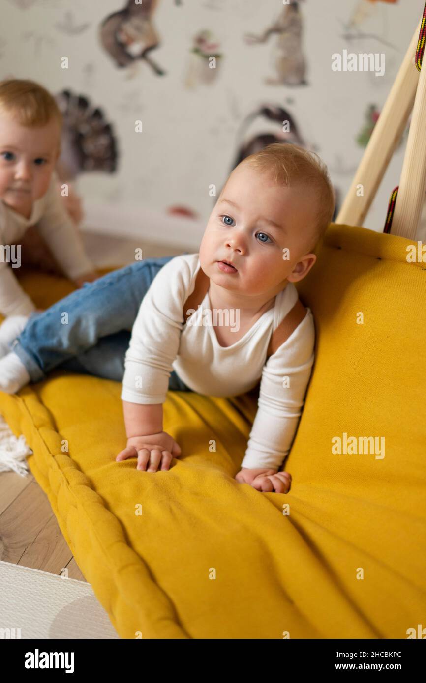 Twin babies playing on couch at home Stock Photo Alamy