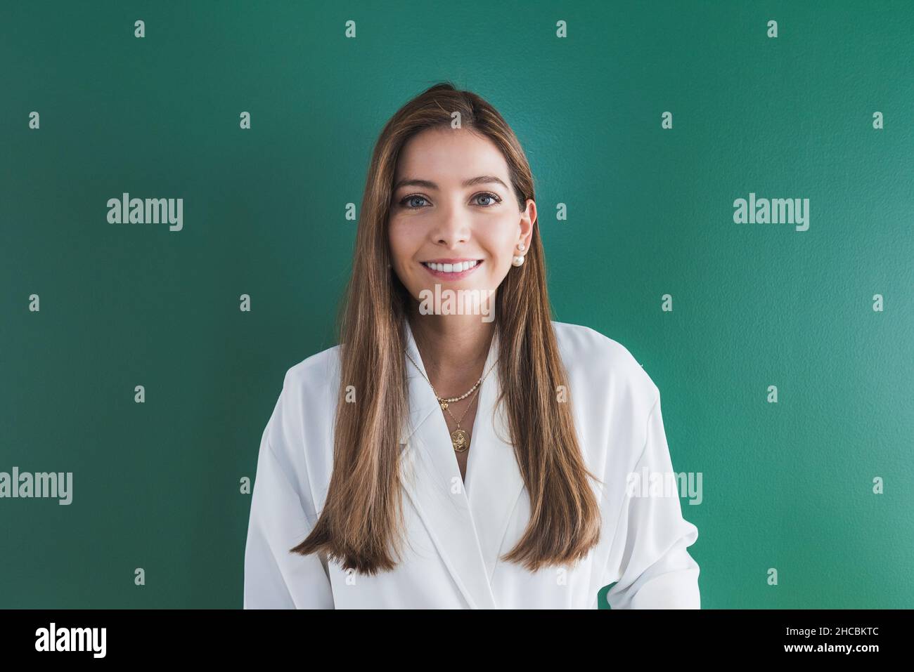 Beautiful woman with brown hair against green background Stock Photo
