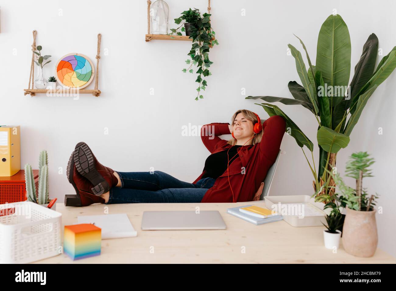 https://c8.alamy.com/comp/2HCBM79/carefree-businesswoman-with-headphones-relaxing-at-creative-office-2HCBM79.jpg