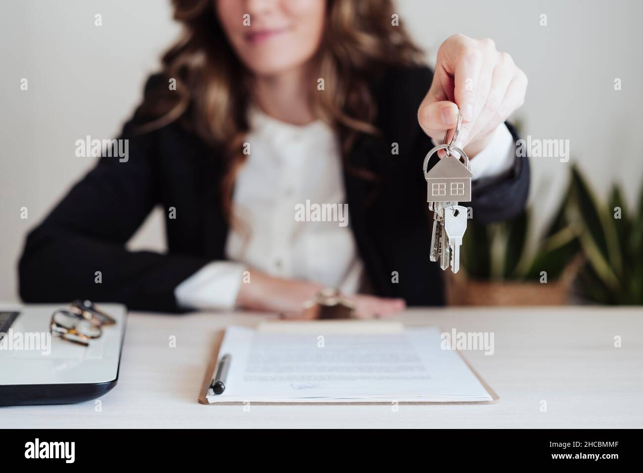Young saleswoman holding house keys Stock Photo