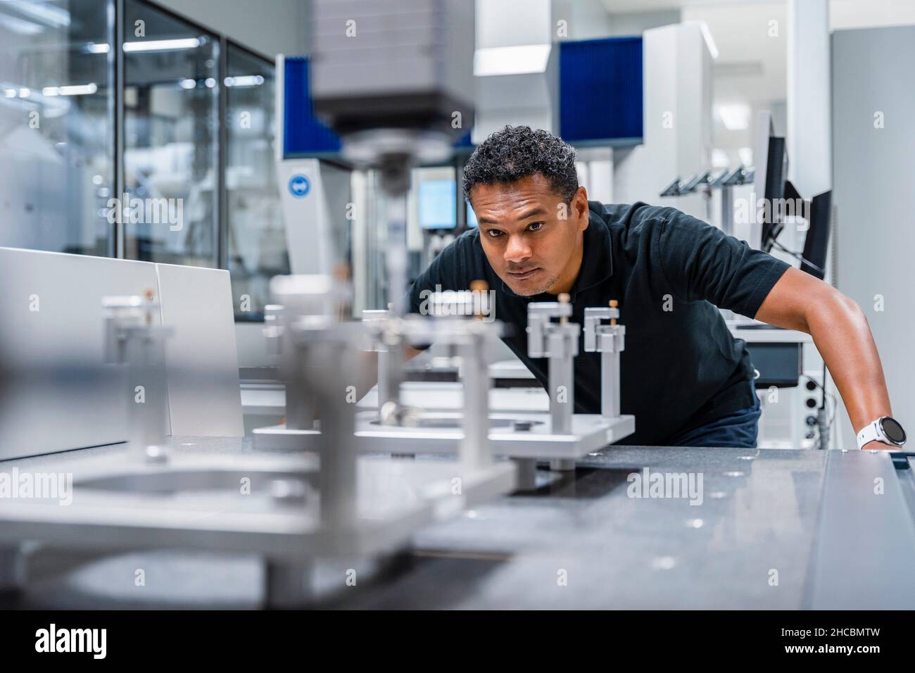 Engineer examining automated machine in factory Stock Photo