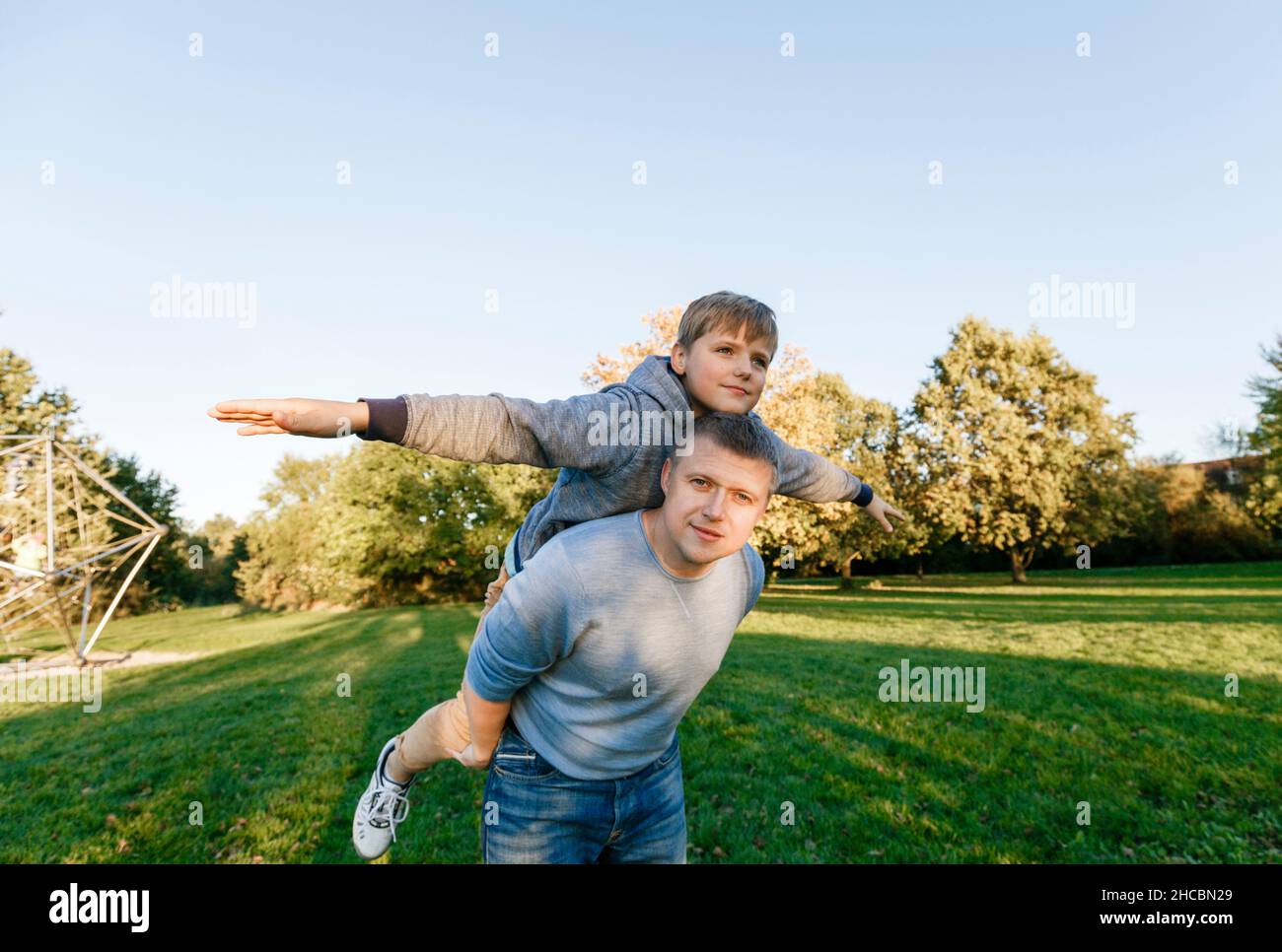 Man playing with blond son at park Stock Photo