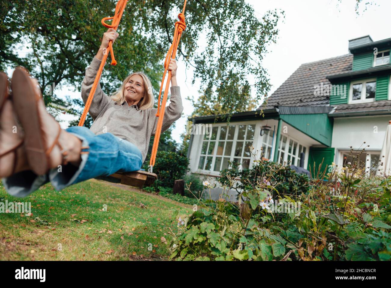 Mature woman sitting on swing hi-res stock photography and images - Alamy