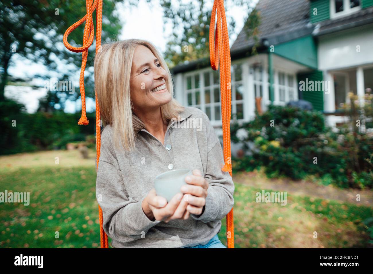 Mature woman sitting on swing hi-res stock photography and images - Alamy