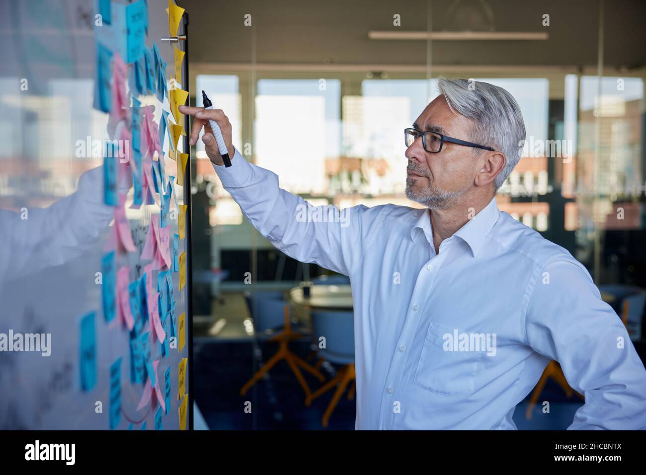 Businessman planning strategy on sticky notes in office Stock Photo