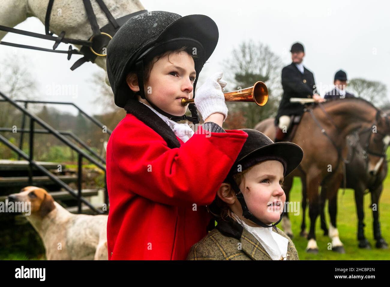 Hagley, Worcestershire, UK. 27th Dec, 2021. 8-year-old Henley Mills stands with his sister Myla-May, 2, among the hounds the first hunt at Hagley Hall since the Coronavirus pandemic. The Albrighton and Woodland Hunt meet annually at Hagley Hall in Worcestershire. Credit: Peter Lopeman/Alamy Live News Stock Photo