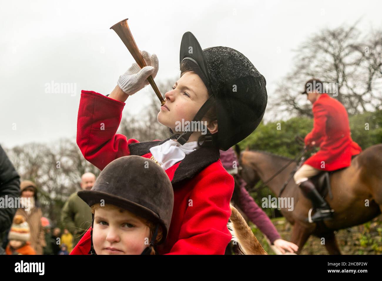 Hagley, Worcestershire, UK. 27th Dec, 2021. 8-year-old Henley Mills with his horn at the first Albrighton and Woodland Hunt meet at Hagley Hall since the Coronavirus pandemic. The Albrighton and Woodland Hunt meet annually at Hagley Hall in Worcestershire. Credit: Peter Lopeman/Alamy Live News Stock Photo