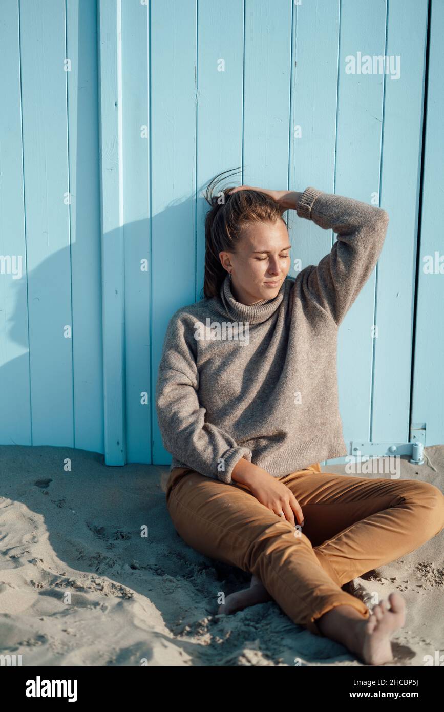 Young woman standing on sand at beach Stock Photo
