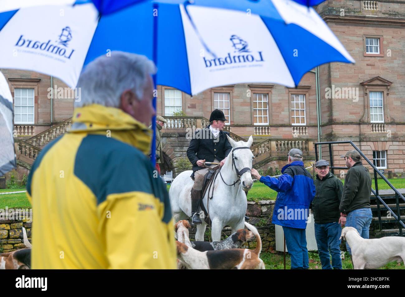 Hagley, Worcestershire, UK. 27th Dec, 2021. Horses and hounds gather with supporters in the rain for the first meet of the Albrighton and Woodland Hunt at Hagley Hall since the Coronavirus pandemic. The Albrighton and Woodland Hunt meet annually at Hagley Hall in Worcestershire. Credit: Peter Lopeman/Alamy Live News Stock Photo