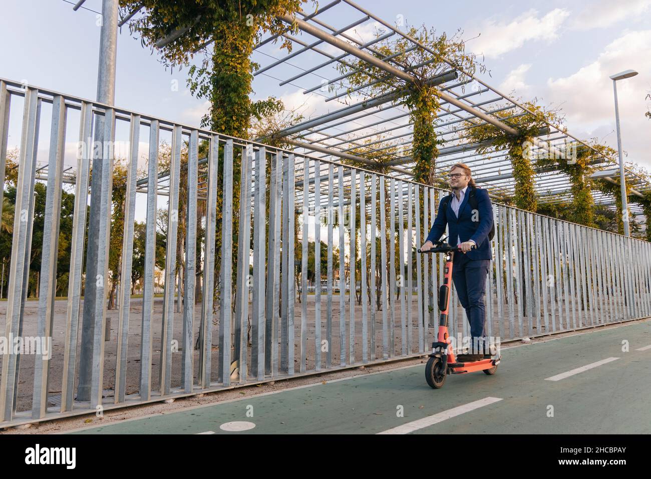 Businessman riding electric push scooter on road Stock Photo