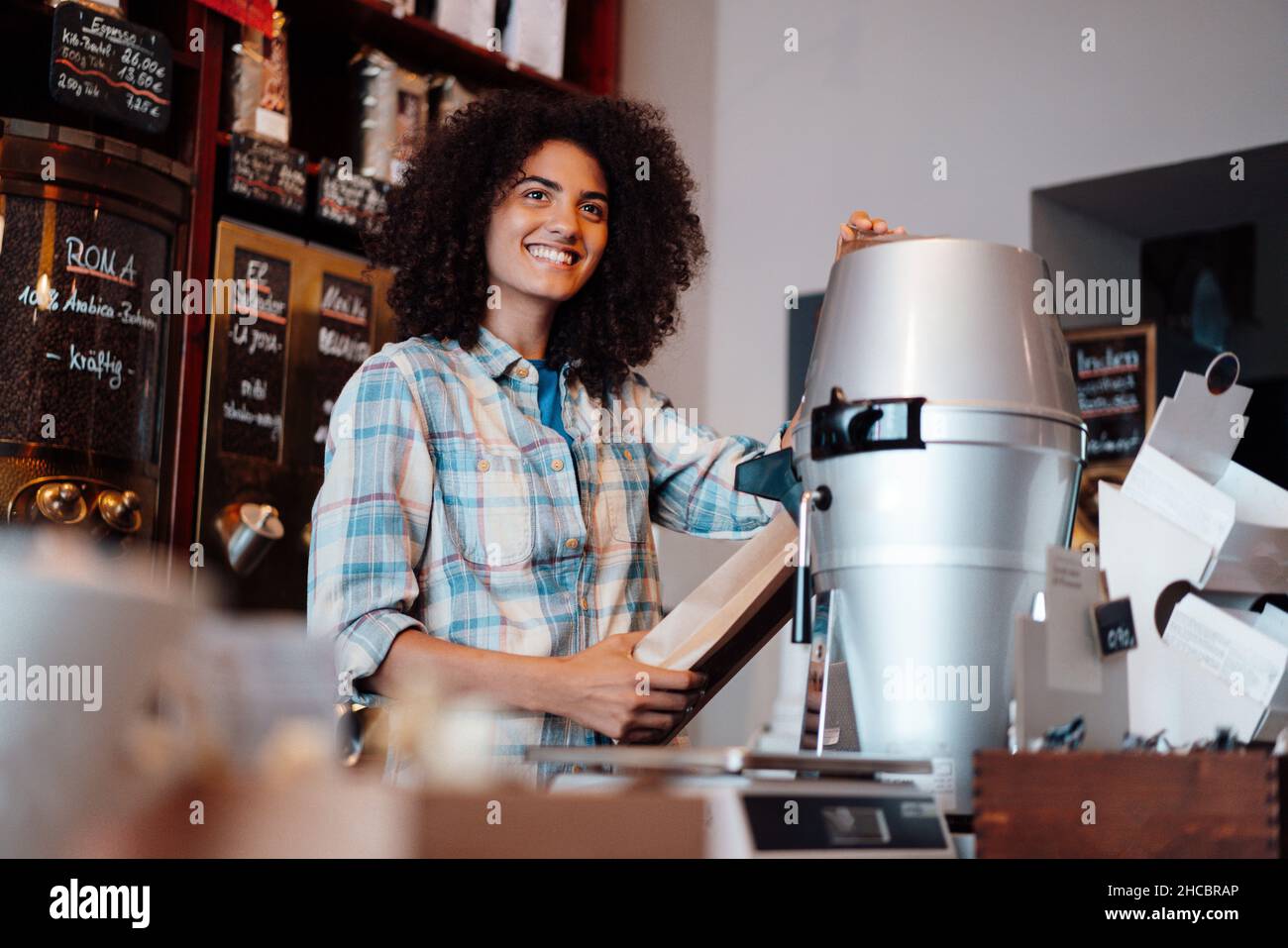 Coffee roaster grinding coffee in store Stock Photo Alamy