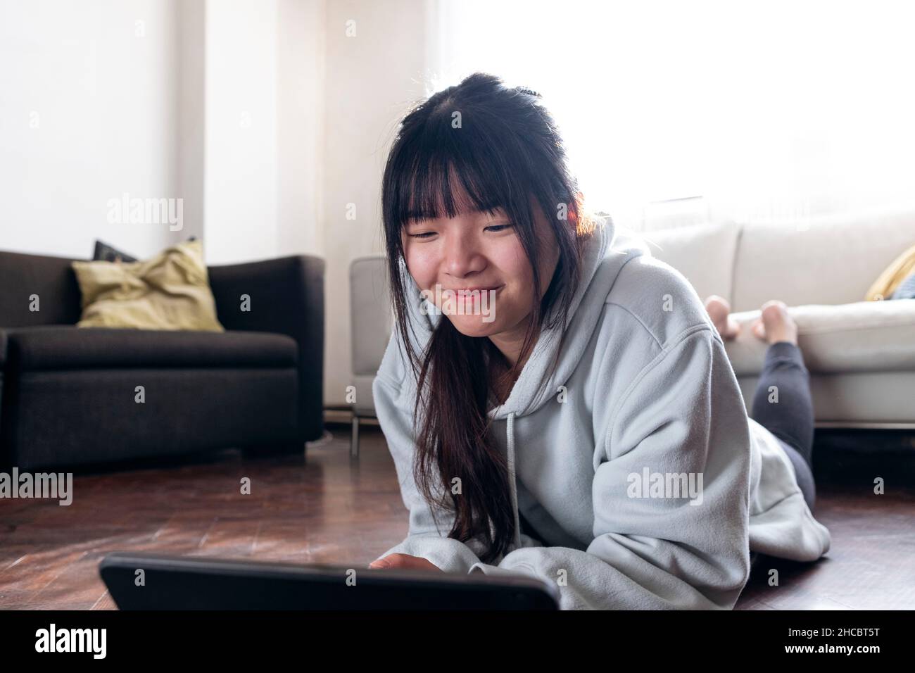 Smiling woman using tablet PC at home Stock Photo