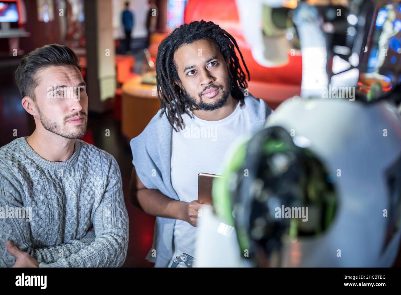 Engineers looking at human robot in workshop Stock Photo