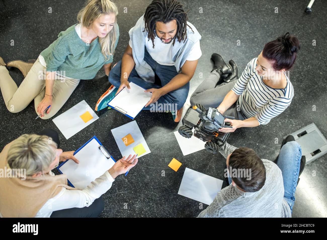 Technicians and engineers discussing with each other holding robotic ...