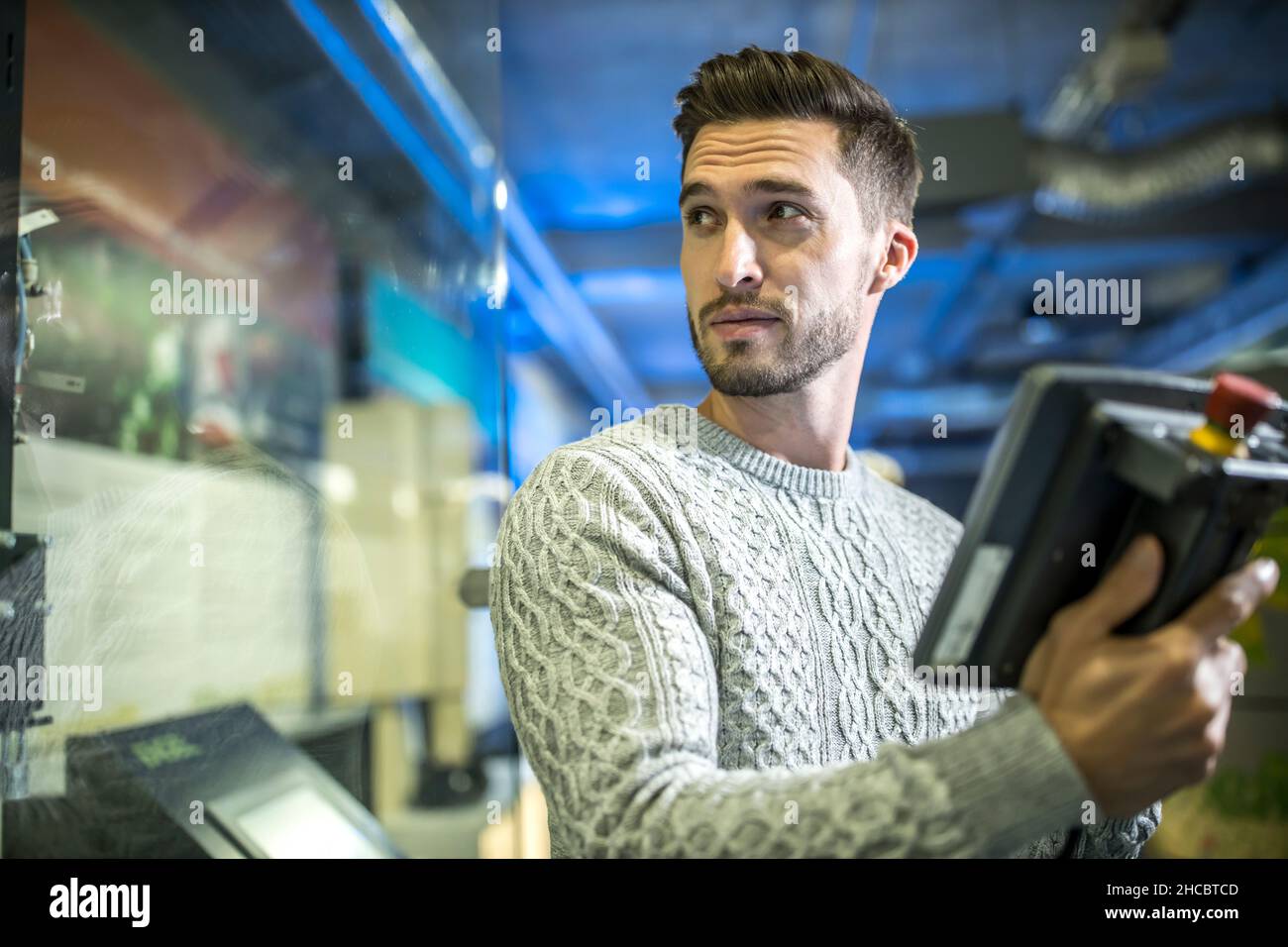 Engineer operating robots at workshop Stock Photo