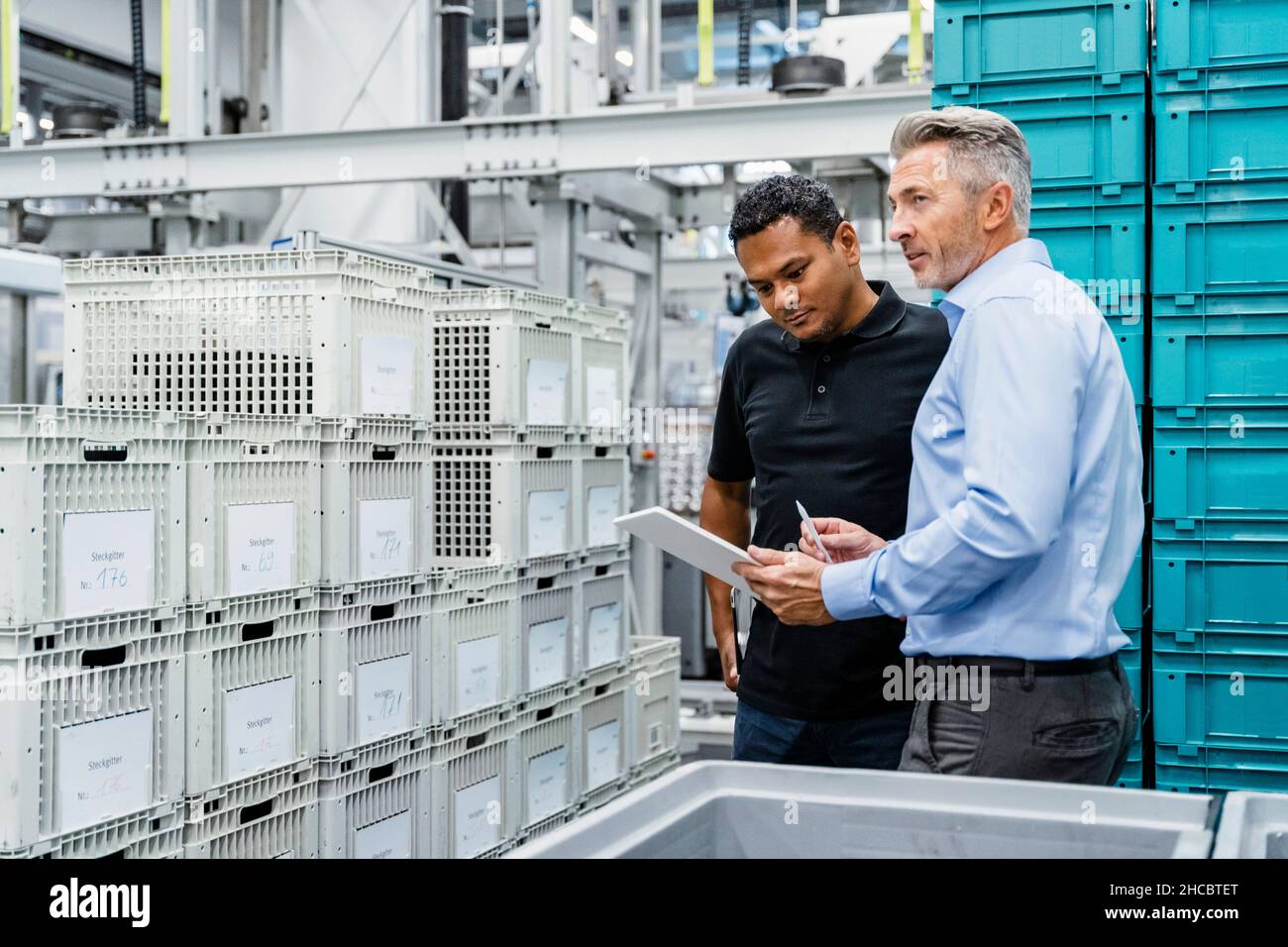 Businessman checking containers with warehouse worker in industry Stock Photo