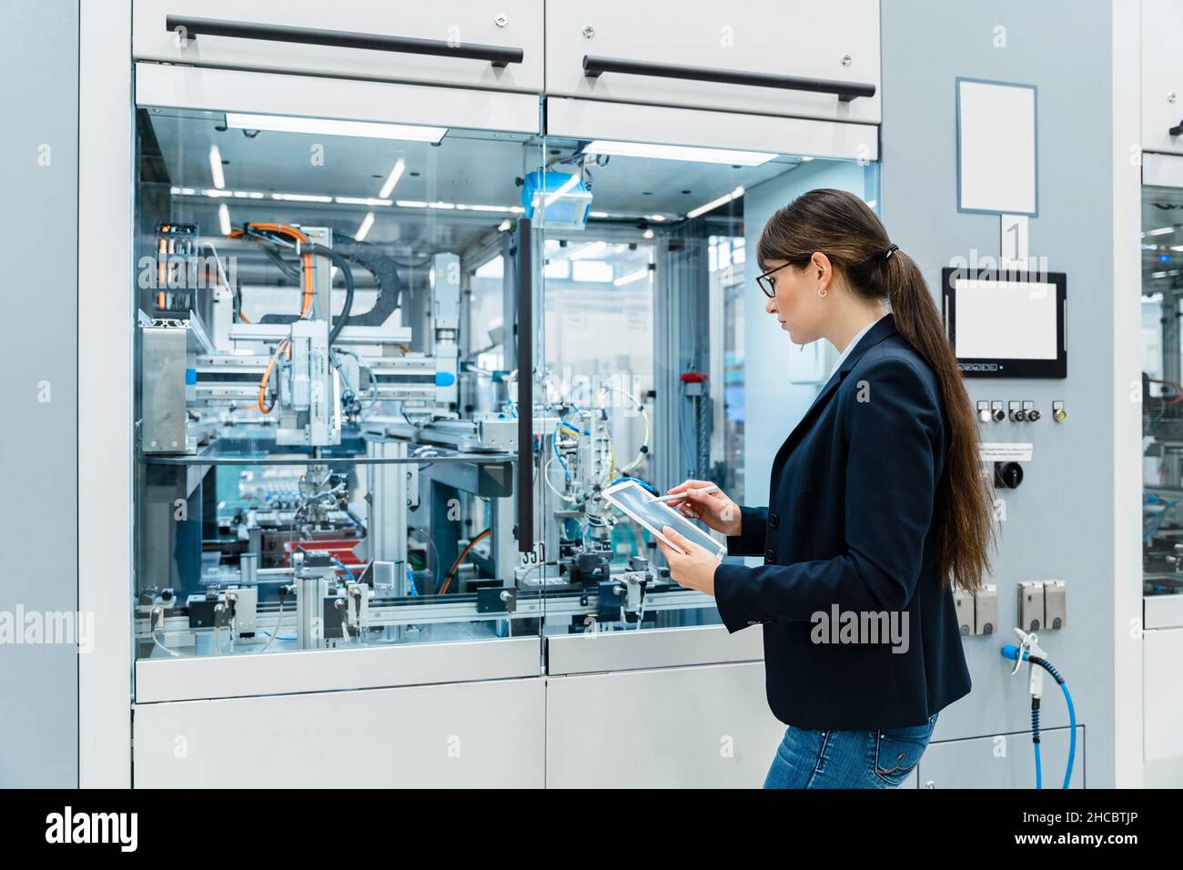 Inspector using tablet PC at industrial machinery Stock Photo