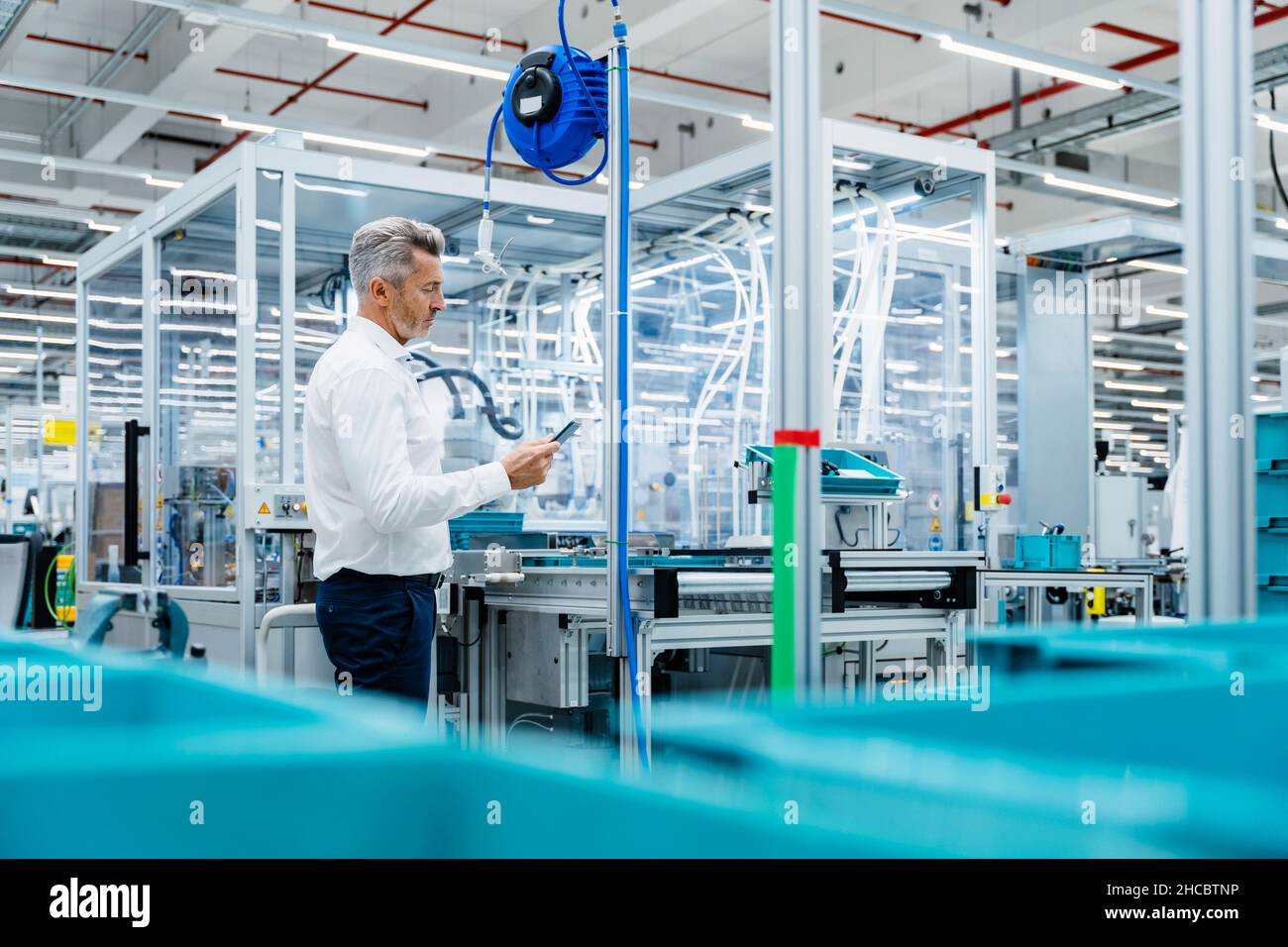 Businessman using digital tablet at production line in factory Stock Photo