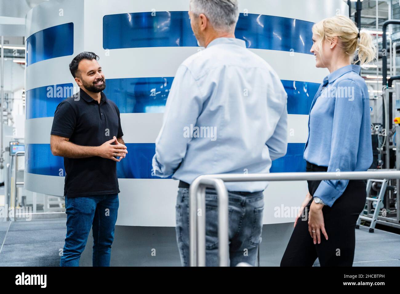 Engineer having discussion with coworkers at automated industry Stock ...