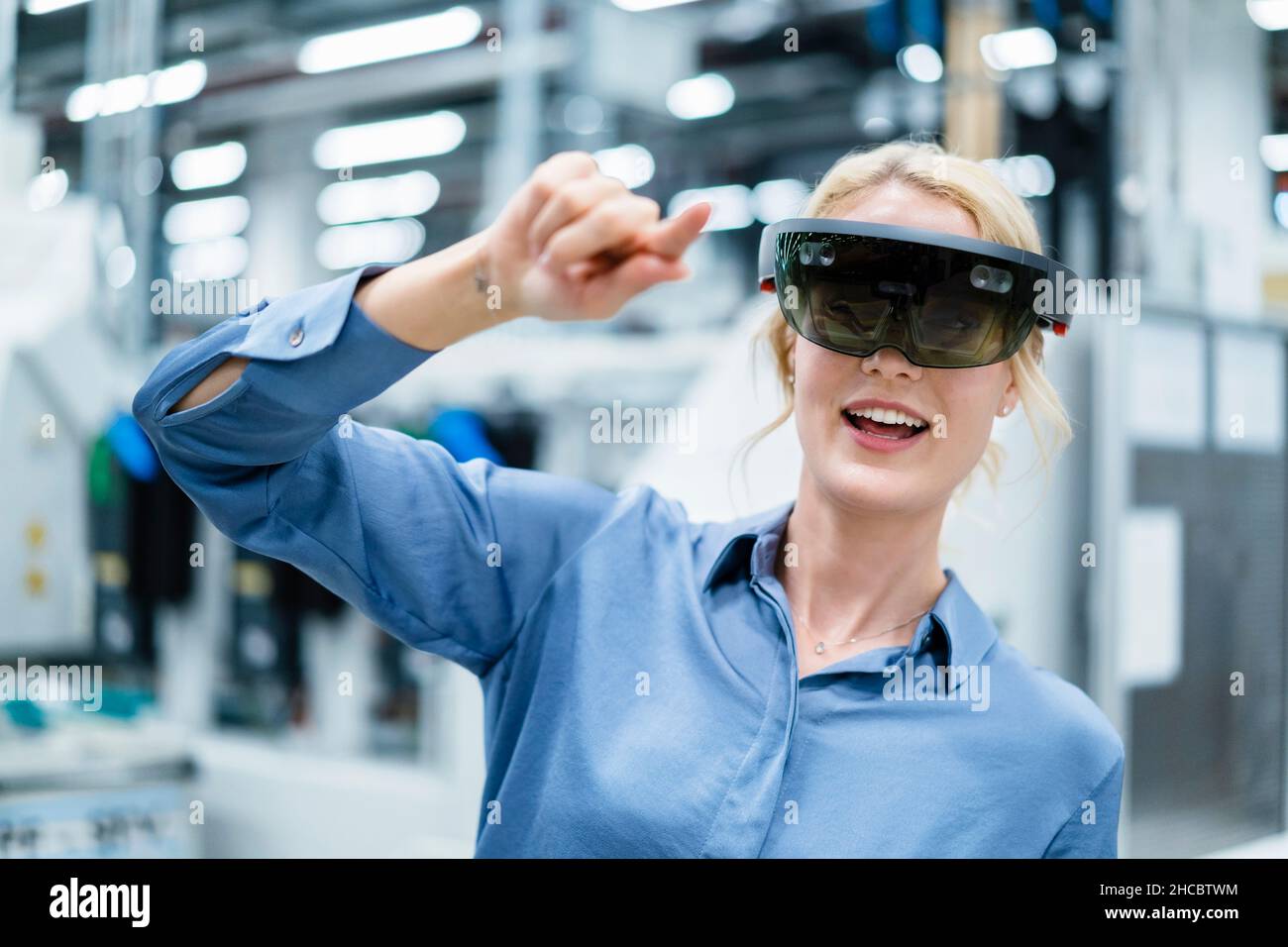 Businesswoman using augmented reality glasses at industry Stock Photo