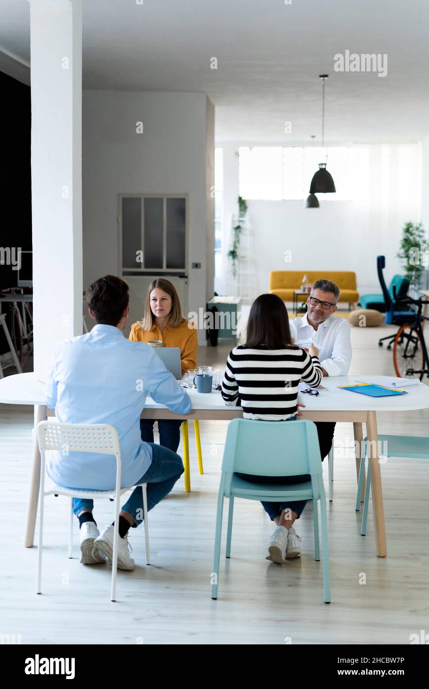 Colleagues sitting at desk working in office Stock Photo
