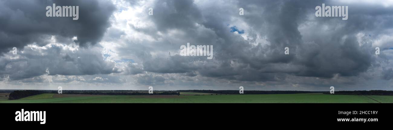 Panorama of gray clouds over green Stock Photo