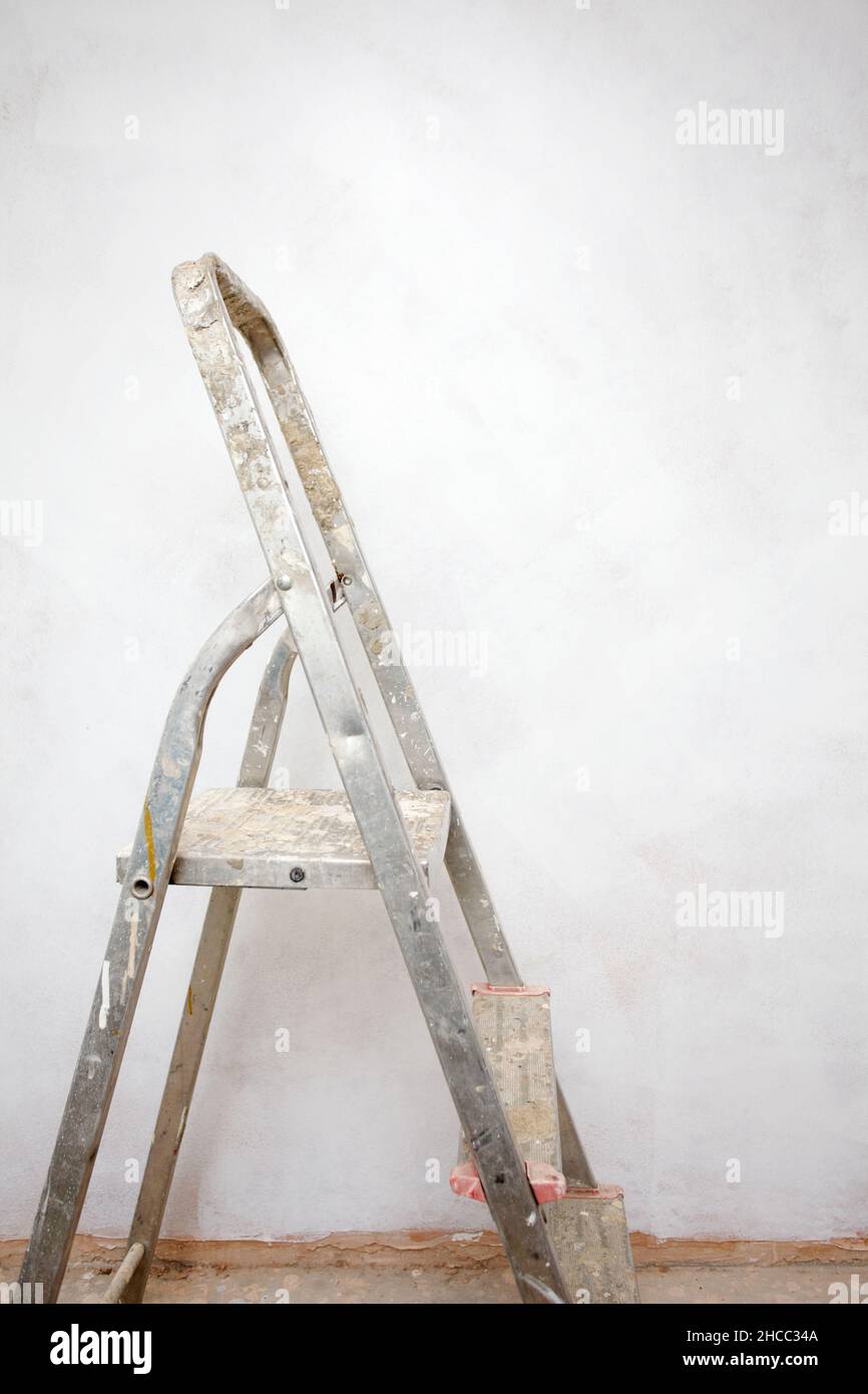 Step ladder next to painted wall Stock Photo