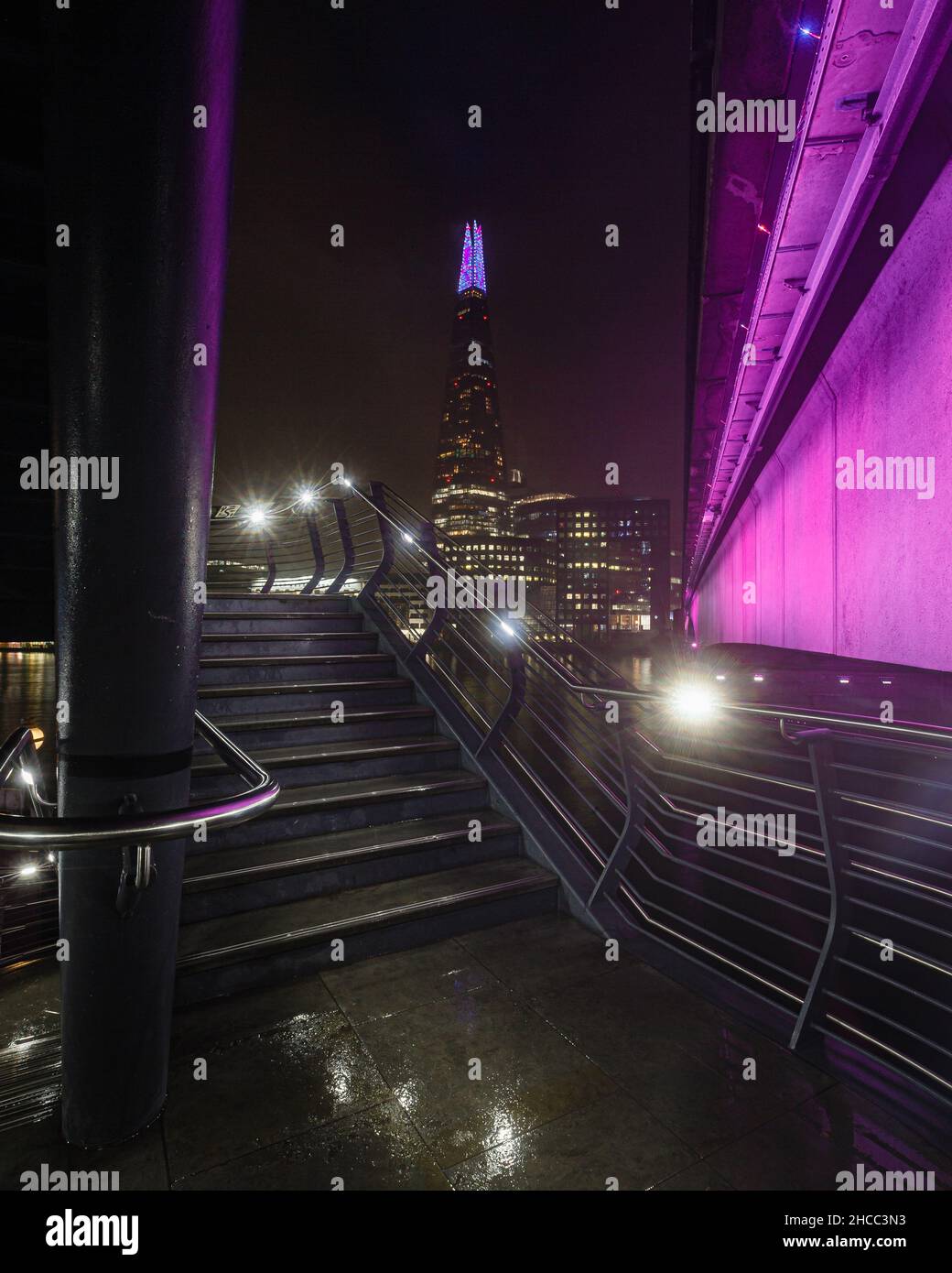 London bridge takes on a pink colour next to an illuminated spiral