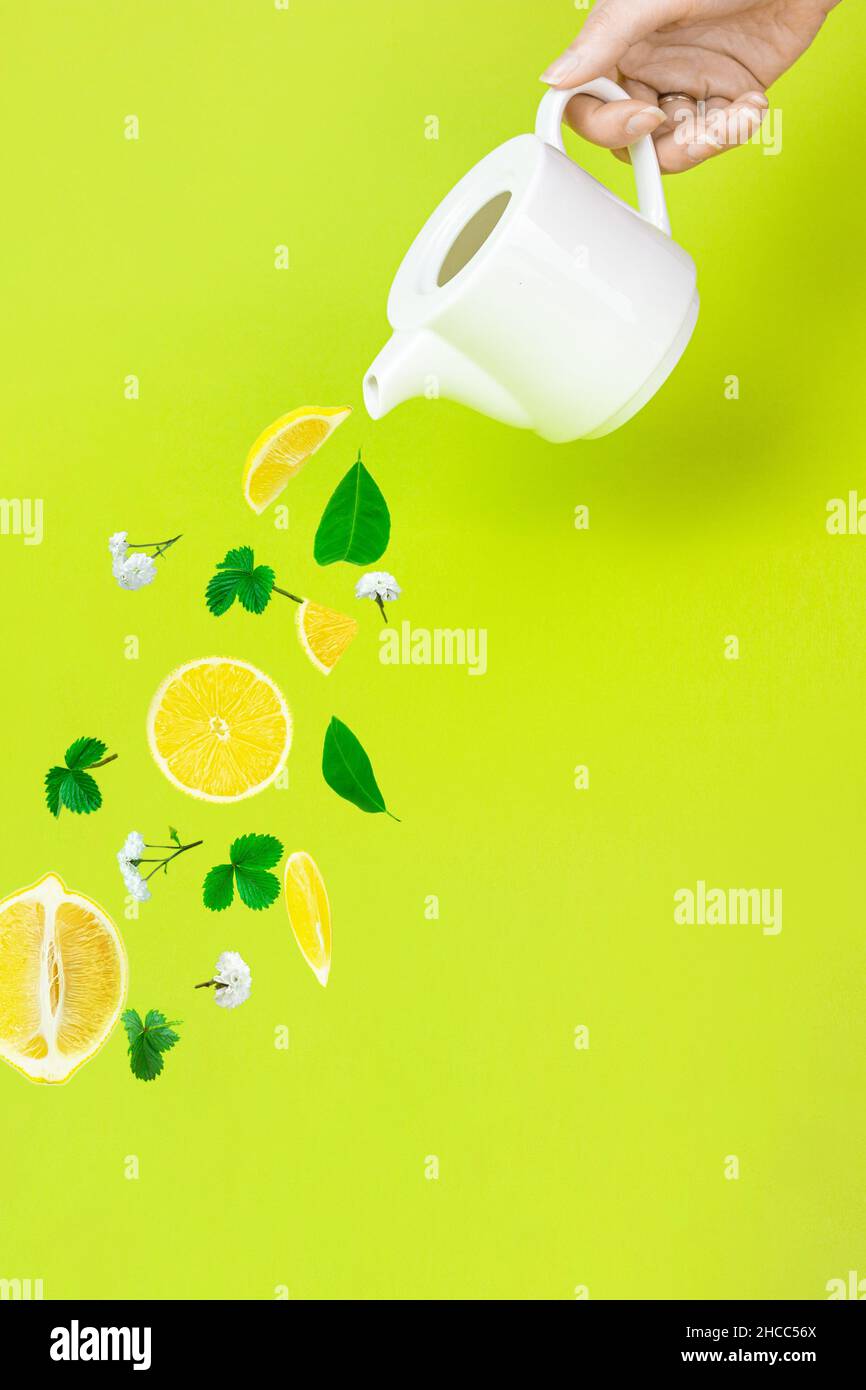 Teapot pouring herbal lemon tea. Herbal healthy drinks, lemon tea