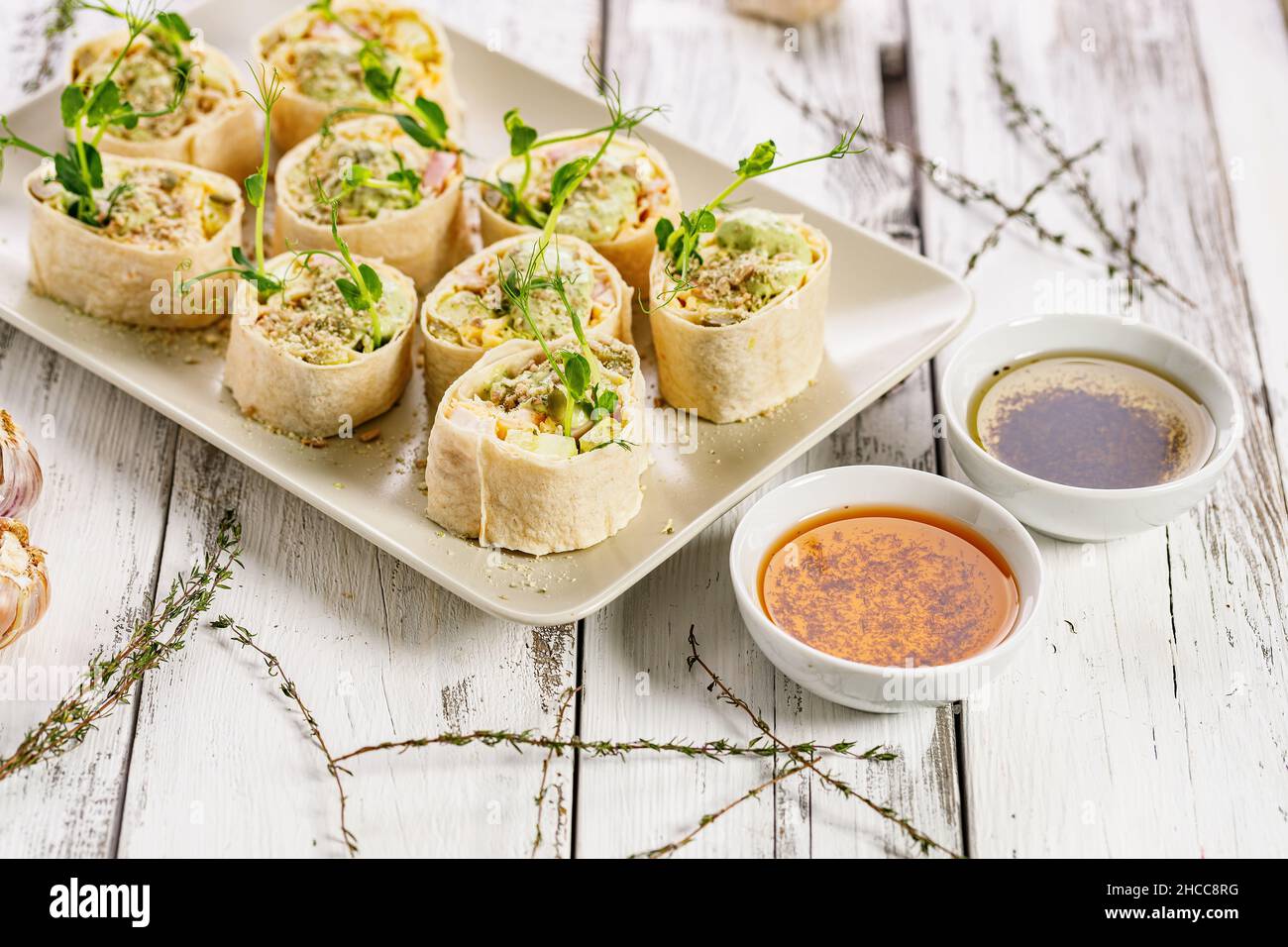 Tortilla deli wrap rolls with chicken ham and vegetable. White rustic background. Olive oil with tomatoes and basil. Wheat sandwich rolls with chicken Stock Photo